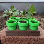 Six-pot pipe-style seed starter set shown with plants for illustration